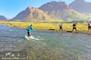 Hiking group passing river- Iran Off the Beaten Adventure