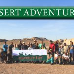 A group in Desert holding Adventure Iran's flag